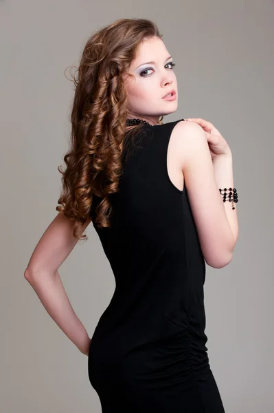 Curly-headed woman in black dress — Stock Photo, Image