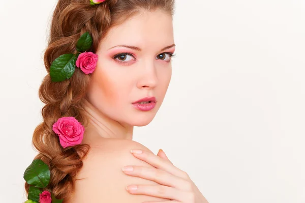 Mujer joven con rosas en el pelo —  Fotos de Stock