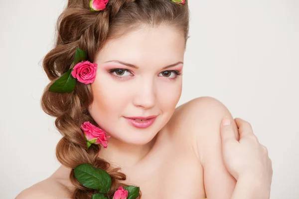 Mujer atractiva con rosas en el pelo —  Fotos de Stock