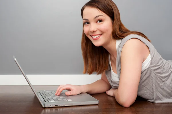漂亮的笑脸女人用的笔记本电脑 — 图库照片