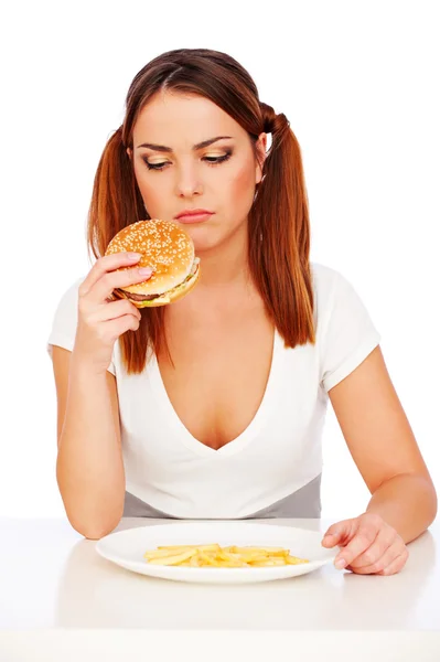Üzgün kadın burger ve patates ile — Stok fotoğraf