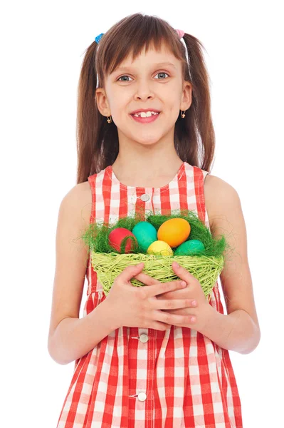 Улыбающаяся девушка держит корзину с разноцветными яйцами — стоковое фото