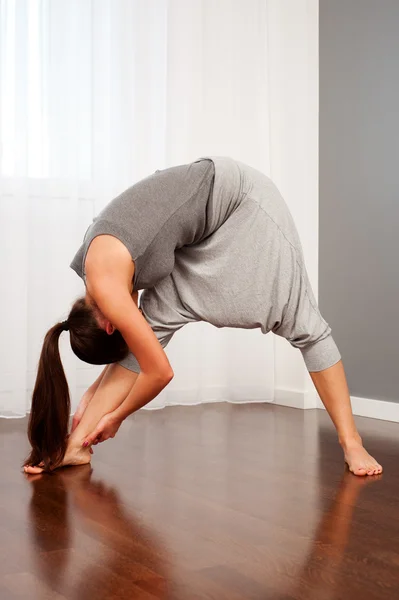Kobieta robi ćwiczenie elastyczności w pokoju — Zdjęcie stockowe