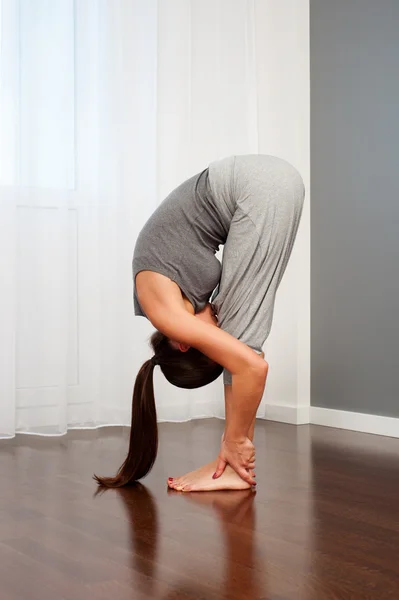 Mujer haciendo ejercicio de flexibilidad en la habitación — Foto de Stock