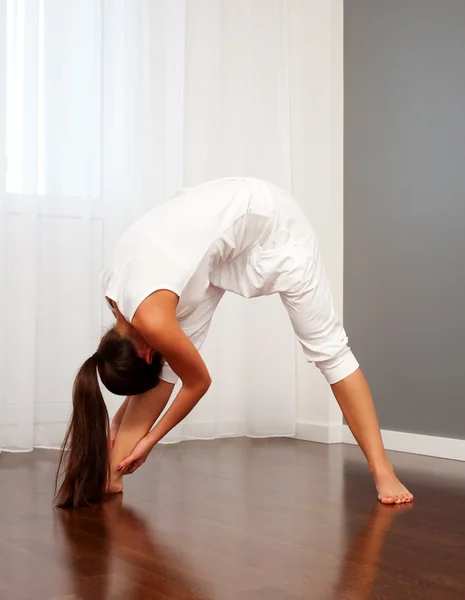Mulher fazendo exercícios de alongamento no quarto — Fotografia de Stock