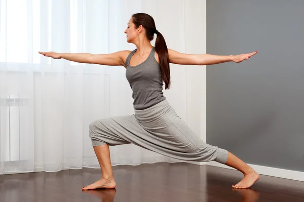 Mulher praticando ioga no quarto — Fotografia de Stock