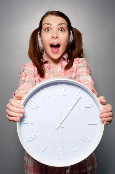Young disturbed woman holding wall clock — Stock Photo, Image