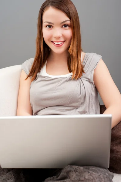 Ung kvinna med bärbar dator Stockbild