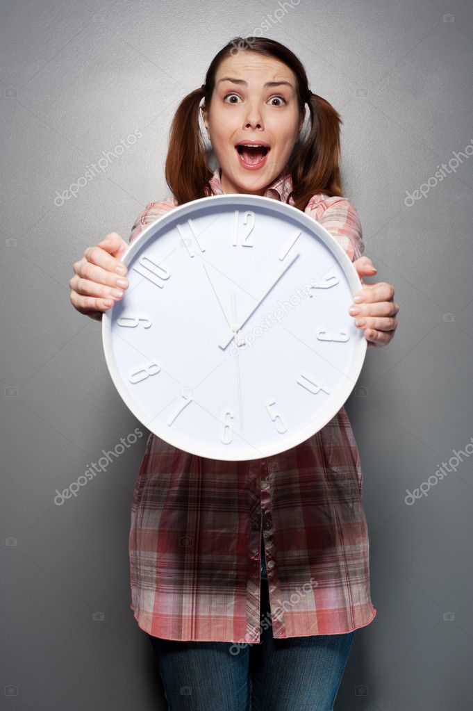 Disturbed woman holding wall clock