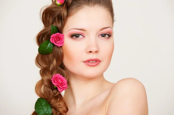Mujer atractiva con rosas en el pelo — Foto de Stock