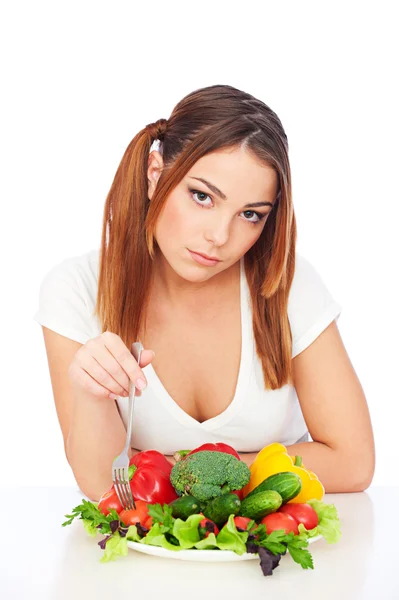 Kobieta siedzi w pobliżu talerz z warzywami — Zdjęcie stockowe