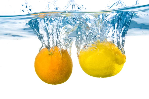 Limão e laranja caíram na água. Close-up — Fotografia de Stock