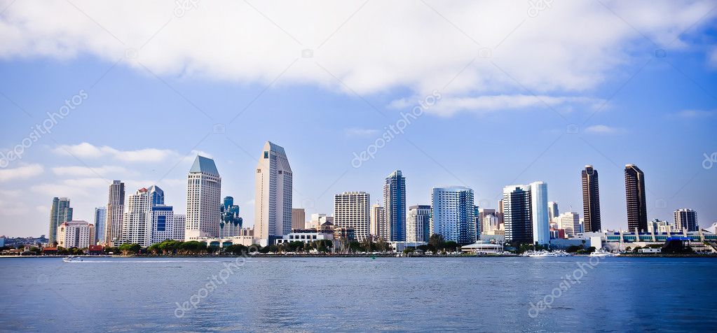 San Diego city skyline at sunset, showing the buildings of downtown rising above harbor viewed from Coronado Island.