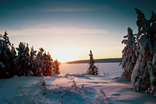 Pôr do sol sobre lago congelado no inverno — Fotografia de Stock