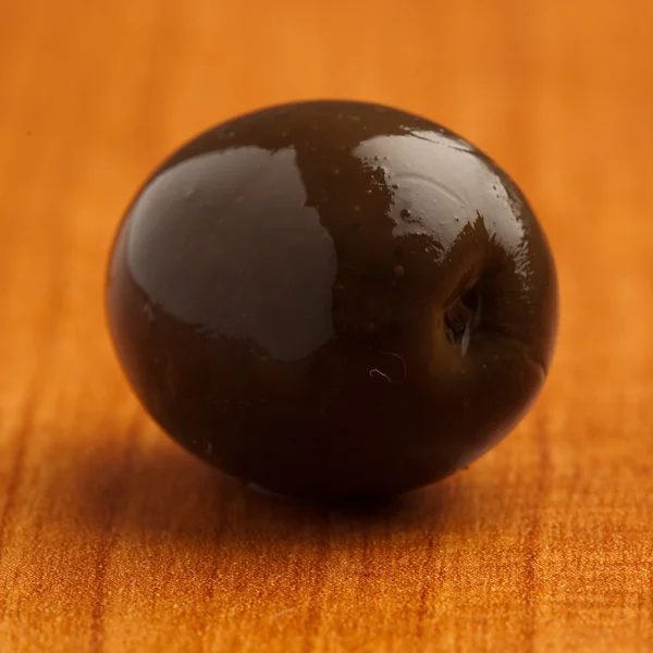 Single Black Olive Wooden Surface — Stock Photo, Image