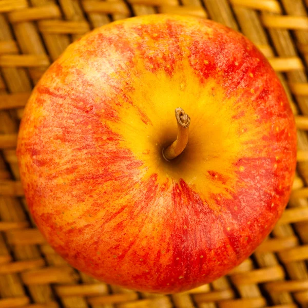 Червоне яблуко на плетеній — стокове фото