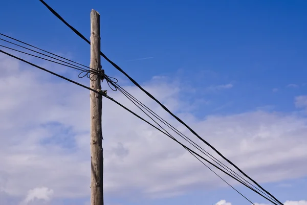 Pólo de transmissão de energia de madeira velha com fios em um fundo de céu — Fotografia de Stock