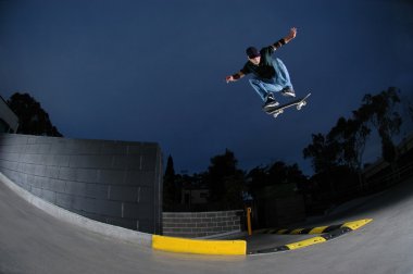 Skateboarder jumping from ledge clipart