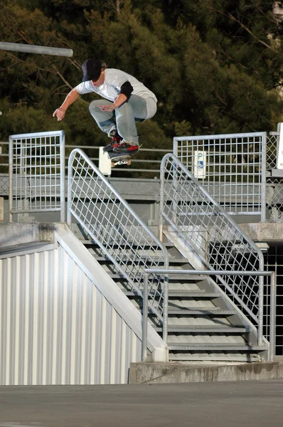 Skateboarder sautant par-dessus une main courante — Photo