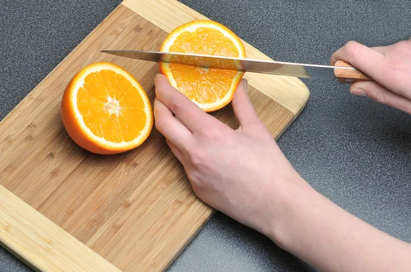 stock image Slicing orange on a table