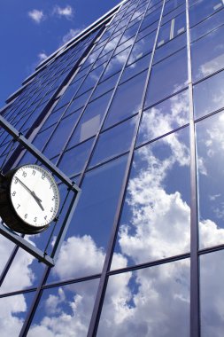 Clock on blue office building background clipart