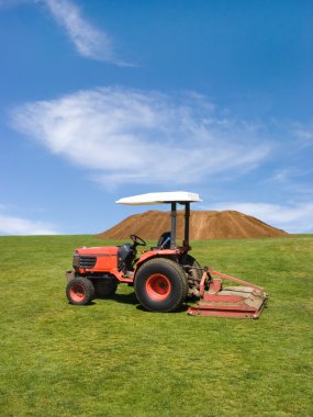 Tractor mowing green field clipart