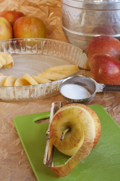 Geschilde appel met taart ingrediënten in de achtergrond Stockfoto