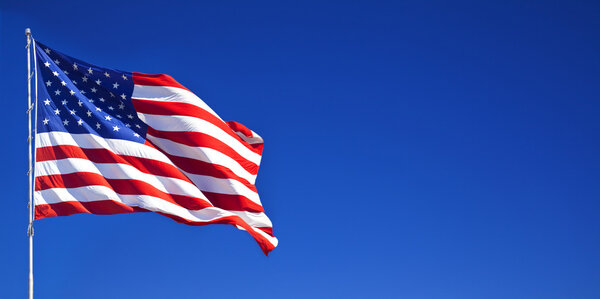 Американский флаг развевается в голубом небе
