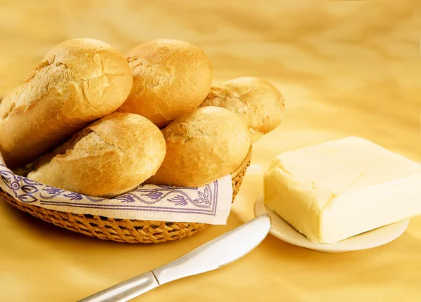 Baguetes em uma cesta e tijolo de manteiga — Fotografia de Stock