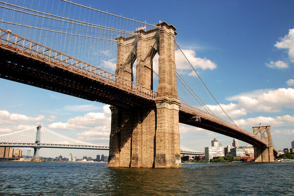 View of the brooklyn bridge in New York City with beautiful blue sky in background.