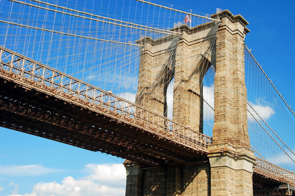 Brooklyn bridge in New York City with beautiful blue sky in background.