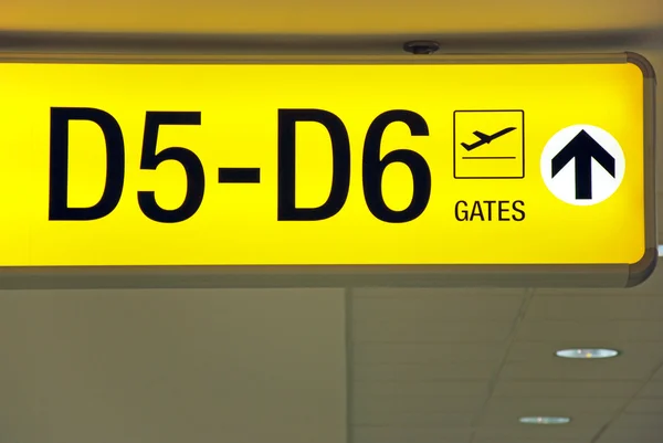 Детальный вид желтого знака вылета из аэропорта, указывающий направление к воротам — стоковое фото