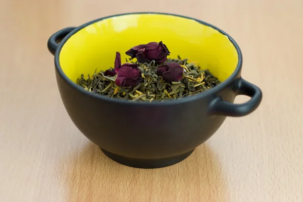 Hoge kwaliteit groene thee close-up met droge rozen in de een gele kom — Stockfoto