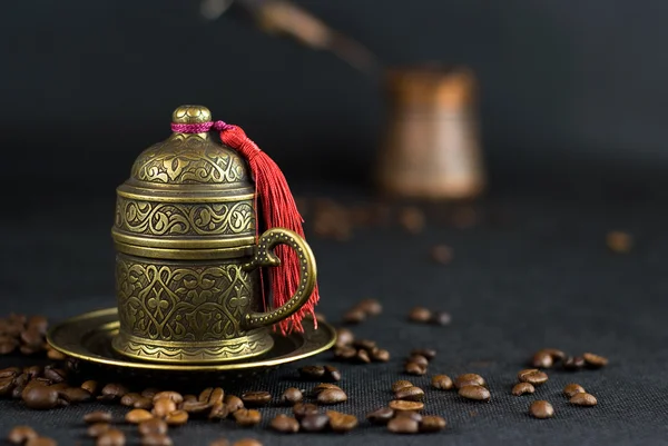 Café espalhado contra uma antiga xícara turca para café — Fotografia de Stock