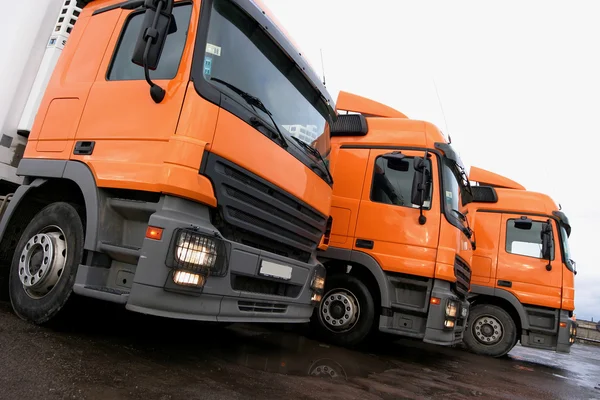 Drei Orangefarbene Lastwagen Stockbild