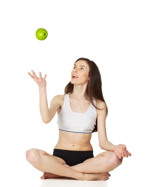 stock image Girl in the lotus position throws apple