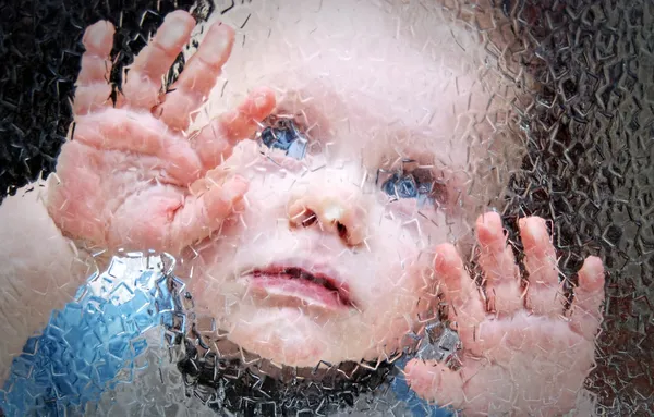 Bambino dietro il vetro . Foto Stock