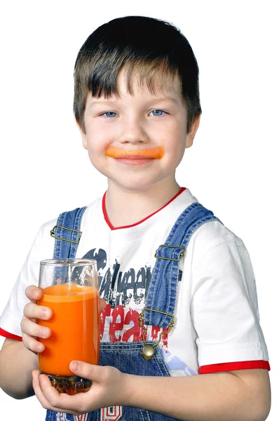 stock image The boy has control over a glass of carrot juice