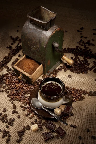 Old coffee mill and cup of coffee with chocolate — Stock Photo, Image