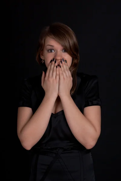Μια νεαρή κοπέλα που κλείνει το στόμα της τα χέρια της — Φωτογραφία Αρχείου