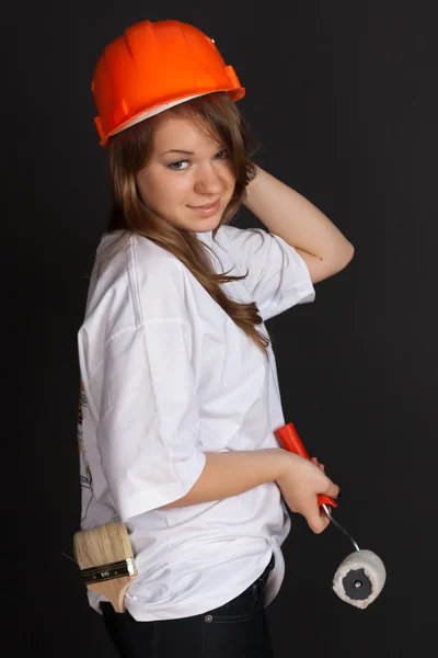 La ragazza col casco arancione con un rullo in mano — Foto Stock