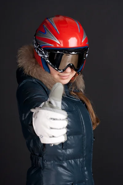 Uma garota em roupas de esqui levanta um grande polegar para cima — Fotografia de Stock