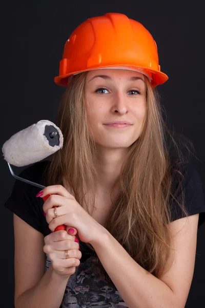 Chica en un casco con un rodillo en la mano — Foto de Stock