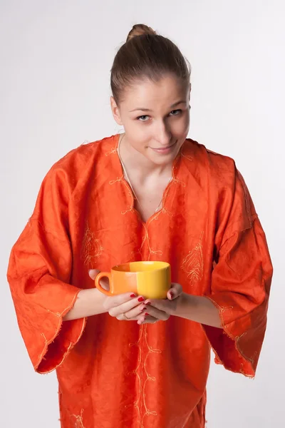 Bir kupa ile Turuncu elbiseli kız — Stok fotoğraf