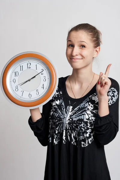 Beautiful girl with a big clock in his hands — Stock Photo, Image
