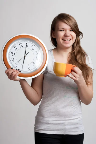 Portrét dívky s šálkem a hodiny — Stock fotografie