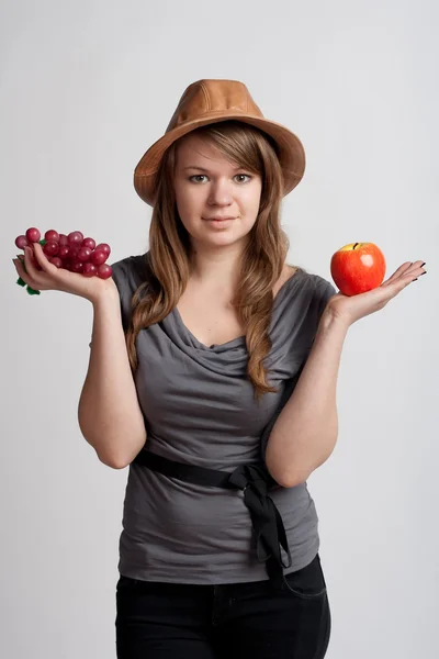 少女の手の中にリンゴとブドウ — ストック写真