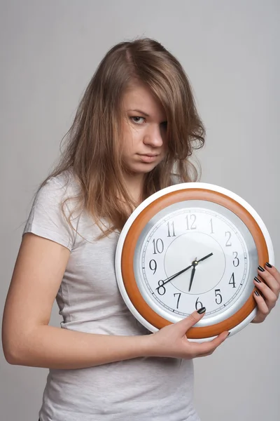Schlafendes Mädchen mit einer großen Uhr in seinen Händen — Stockfoto