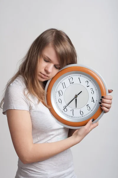 Menina dormindo com um grande relógio em suas mãos — Fotografia de Stock
