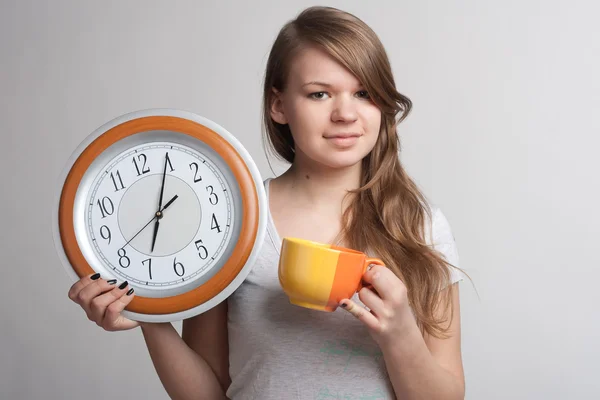 Portrait d'une fille avec une tasse et une horloge — Photo